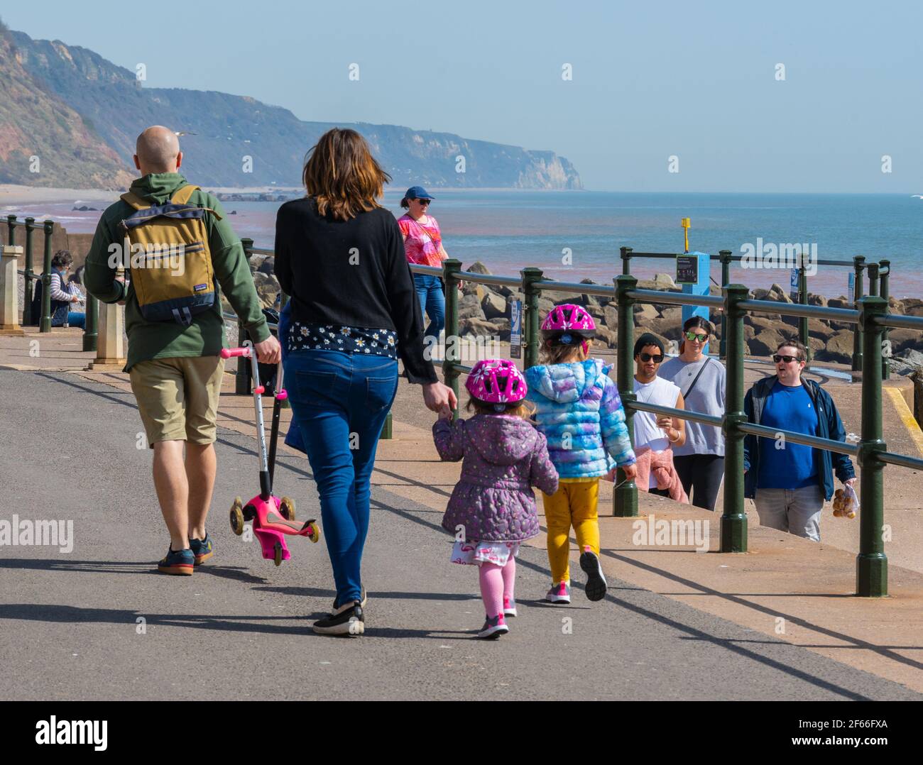Sidmouth, Devon, Großbritannien. März 2021, 30th. Wetter in Großbritannien: Die Menschen strömen in den Badeort Sidmouth, Devon, um die herrliche Sonne zu genießen, während die Südküste vor dem Osterfeiertagswochenende in einer Mini-März-Hitzewelle sonnt. Man sah die Leute an diesem Nachmittag entlang der hübschen Esplanade spazieren gehen und die heiße Sonne im hübschen Regency Resort genießen. Kredit: Celia McMahon/Alamy Live Nachrichten Stockfoto
