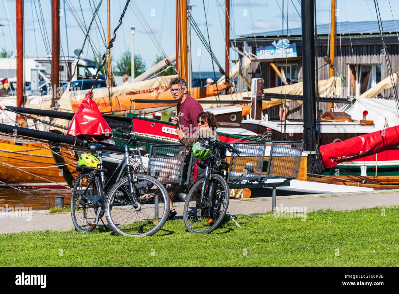 Fahrradtouristen im Hafen von Bodstedt am Barther Bodden besichtigen die Zeesenboote die Erbe liegen Stockfoto