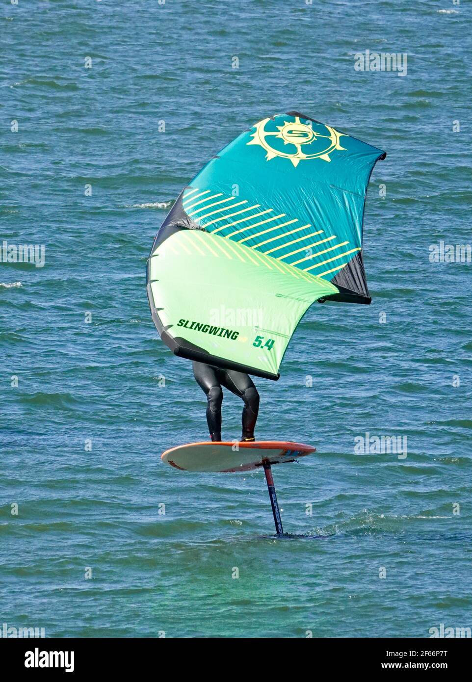 Ein Mann, der auf dem Columbia River in der Columbia River Gorge in der Nähe von Hood River, Oregon, auf einer Wing Foil, oder Sling Wing, oder Slingshot, Bord segelt. Stockfoto