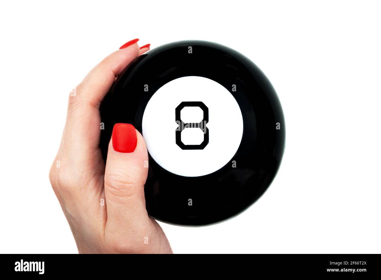 Magic 8 Ball von Vorhersagen in weiblicher Hand mit rot Nägel auf weißem Hintergrund isoliert Stockfoto