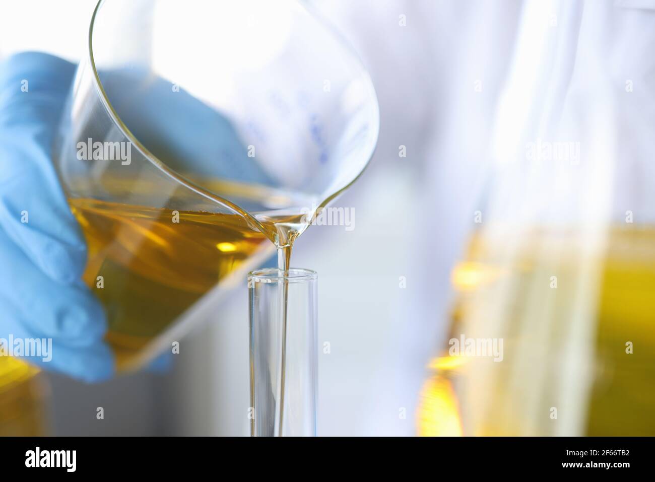 Wissenschaftler Chemiker Gießen Öl aus Kolben in Glas Nahaufnahme Stockfoto
