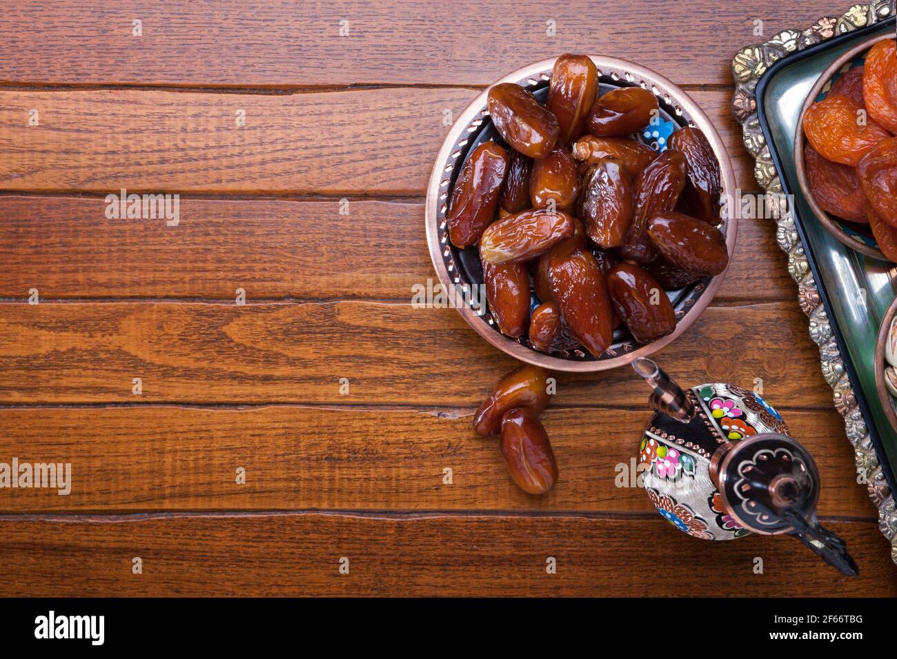 Teller mit Datteln, Kaffeekanne auf braunem Holztisch. Ramadan Hintergrund. Draufsicht. Stockfoto