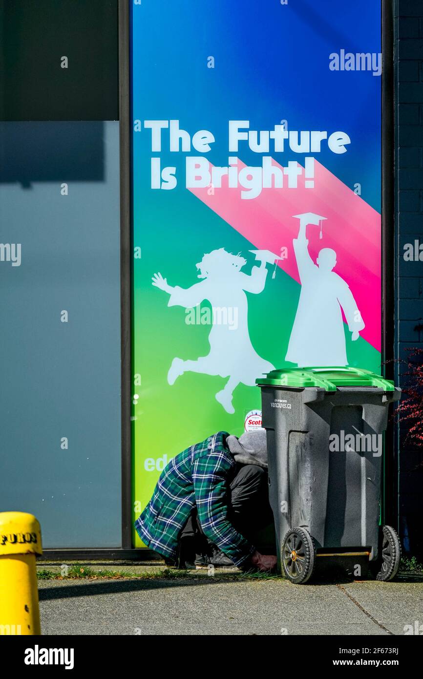 Junger Obdachloser kauerte hinter der Werbung "The Future is Bright", Vancouver, British Columbia, Kanada Stockfoto