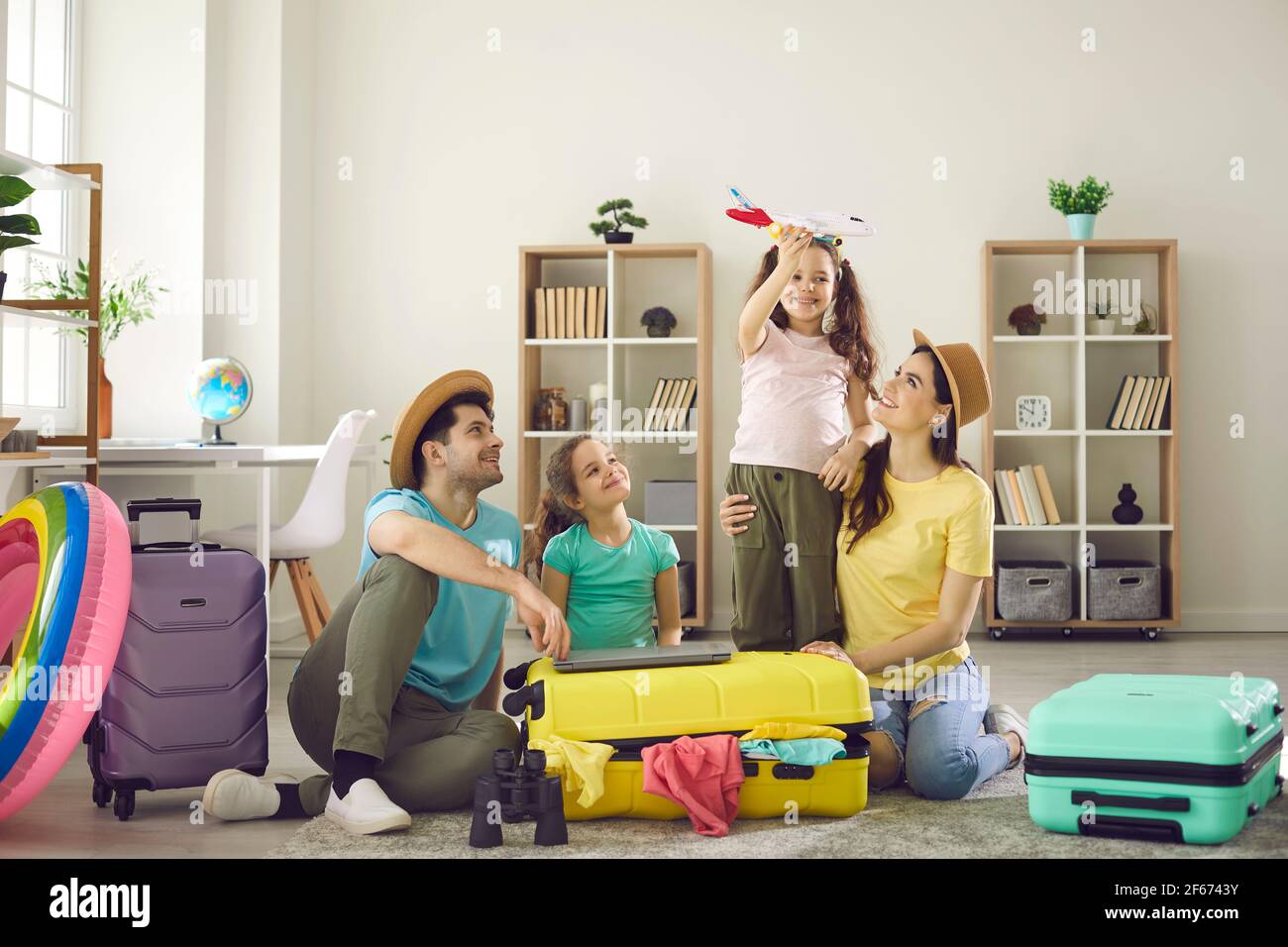 Glückliche Familie mit Kindern auf dem Boden mit verpackten Sachen  Reisekoffer herum Stockfotografie - Alamy