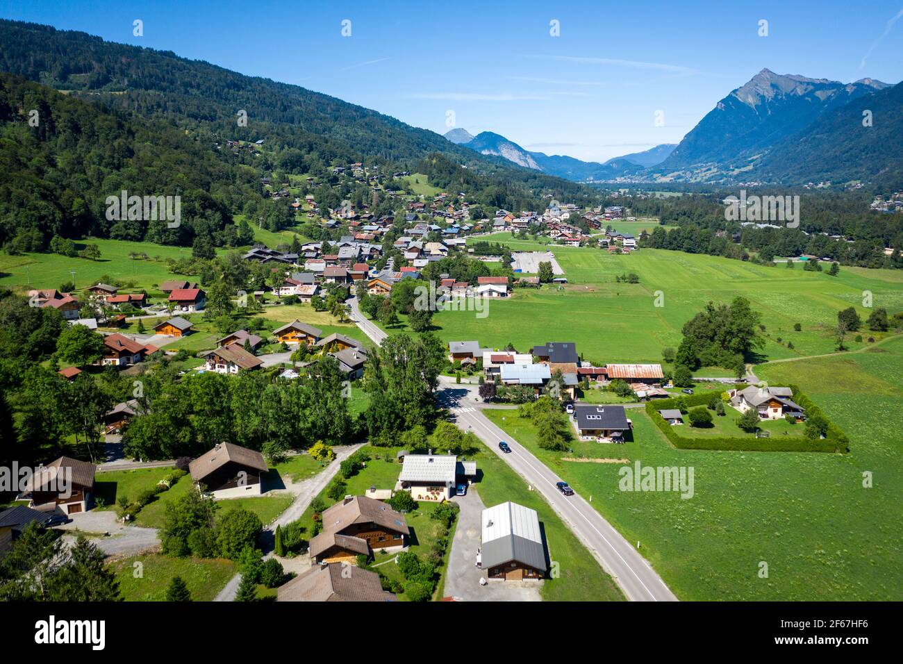 Drohnenansicht von Häusern, die über grüne Wiesen im Bergtal verstreut sind. Schönheit der Giffre-Bergregion, Frankreich. Stockfoto