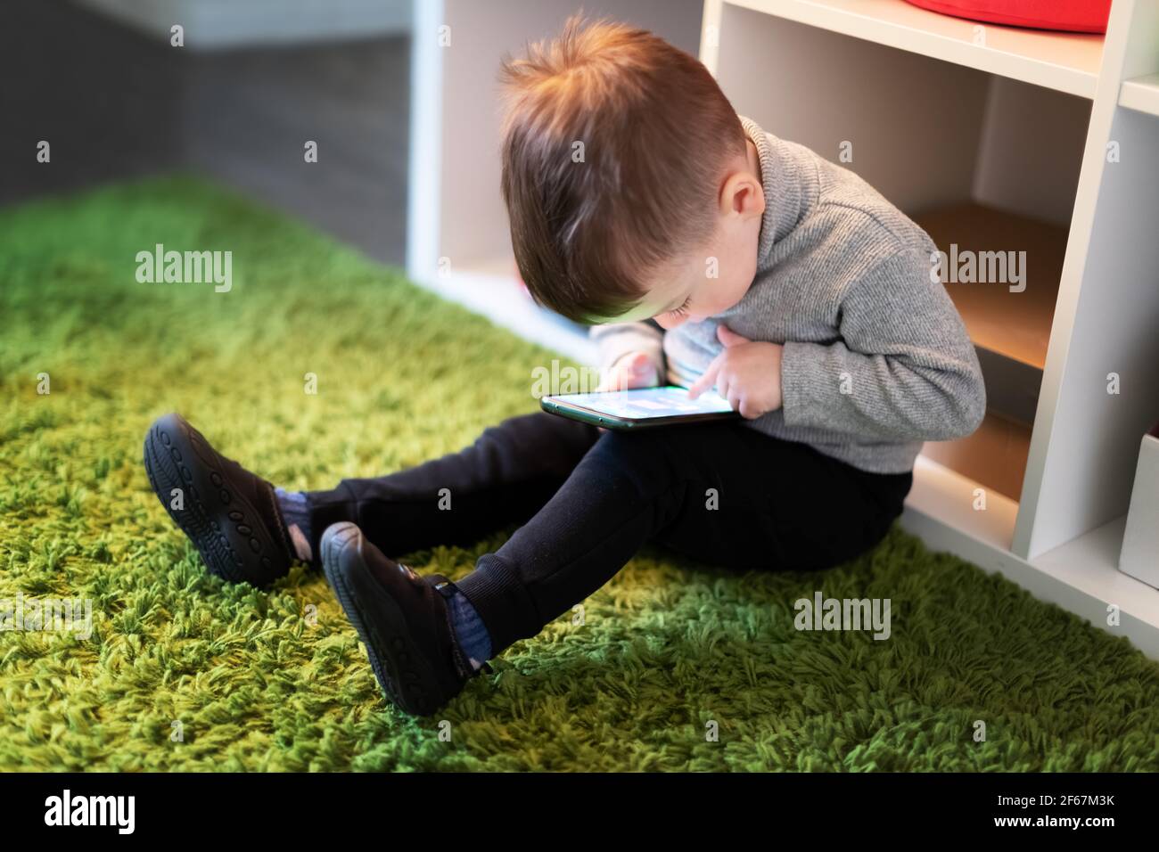 Kleiner Junge spielen Spiele auf dem Smartphone Stockfoto
