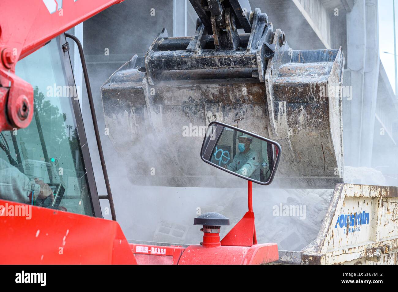 Beschnittene Ansicht des Baggers, der Bauschutt in Stahlcontainer lastet. Verkehrsinfrastruktur Baustellenkonzept. Stockfoto