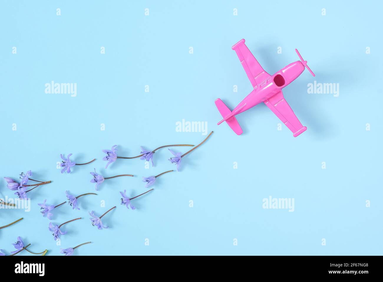 Rosa Flugzeug nimmt in eine scharfe Wendung auf blauem Hintergrund Stockfoto
