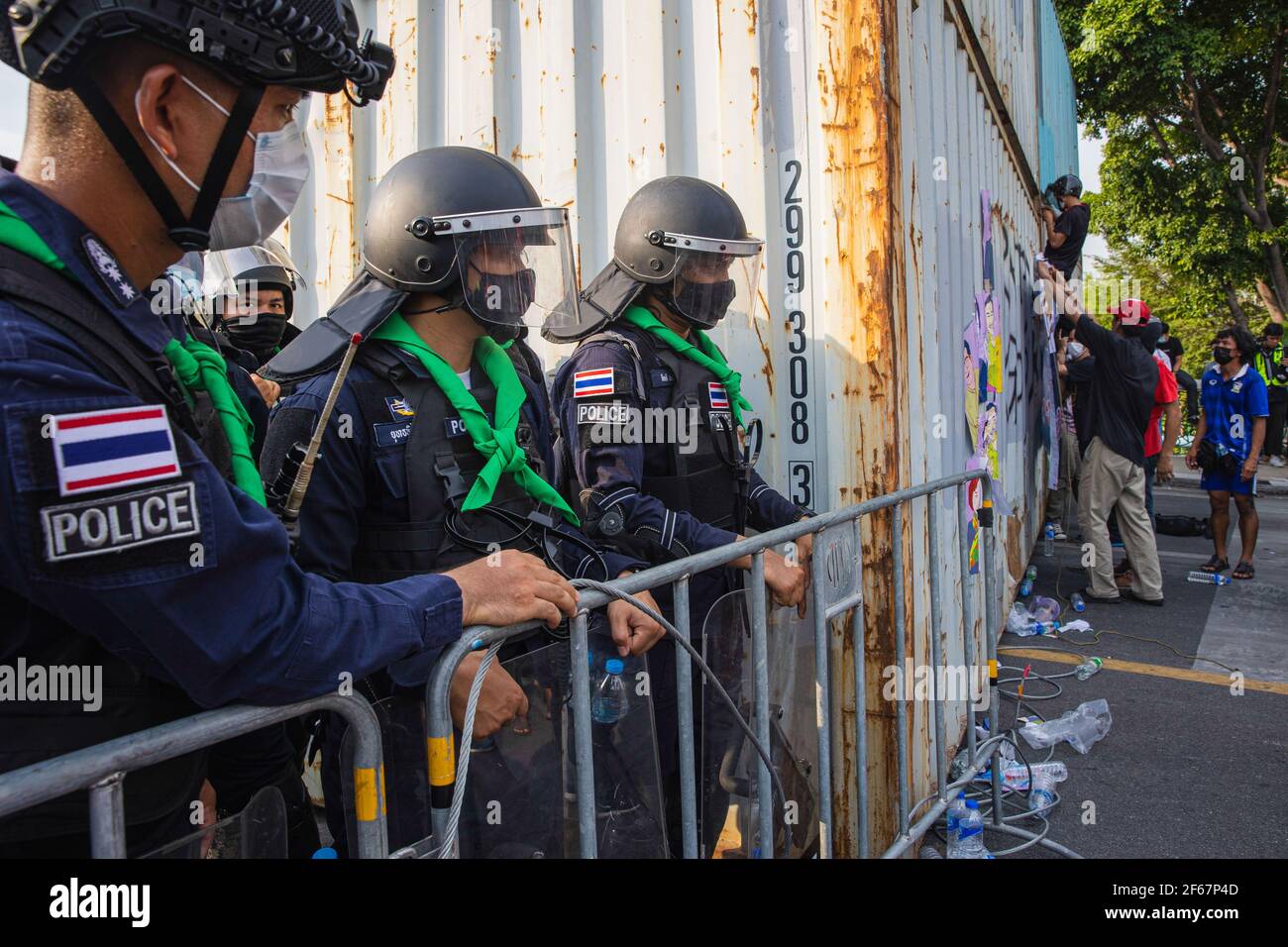 Crowd Control Polizei beobachten Demonstranten kleben Plakat auf intermodale Container während der Demonstration. "Walk through Sky"-Treffen von prodemokratischen Demonstranten am Regierungsgebäude demonstrieren, nachdem sie vom Metropolitan Police Bureau entlassen wurden, das sie in zwei separaten Operationen am Sonntag in der Morgendämmerung und in der Dämmerung zusammenbrachte. Die Demonstranten fordern den Rücktritt von Premierminister Prayut Chan-ocha, Verfassungsreform und Abschaffung des majestestes Gesetzes. Stockfoto