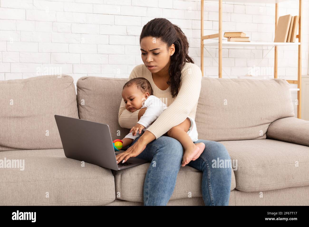 Schwarze Mutter Mit Baby Kleinkind Arbeiten Auf Laptop Zu Hause Stockfoto