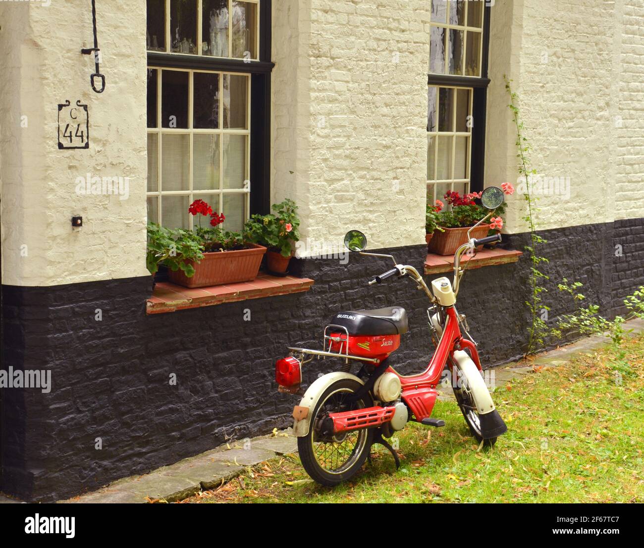 BRÜGGE, BELGIEN, EUROPA,1ST. JULI , 2017. Ein schönes rotes Vintage-Motobike, das vor einem schönen Haus in den Straßen von Brügge, BELGIEN, geparkt ist Stockfoto