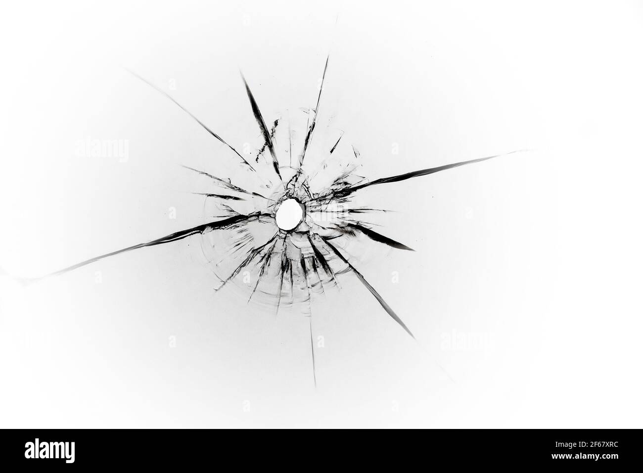 Die Textur der Risse von einer Kugel auf dem Glas. Abstraktion von Schnapsglas für Design. Stockfoto