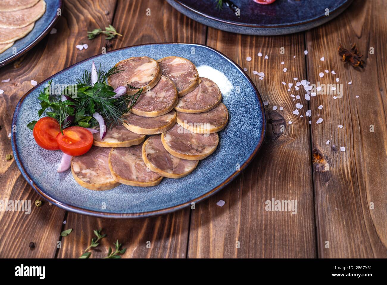 Fleisch- und Wurstaufschnitt, Knoblauch, Chilischoten, Tomaten und andere Gewürze auf einem braunen Hintergrund. Restaurant-Service. Stockfoto