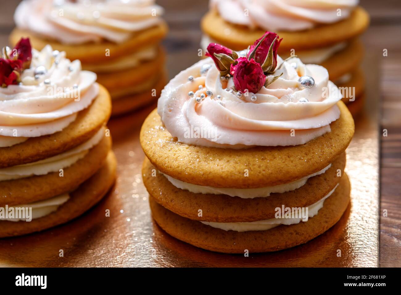 Biskuitkuchen mit Sahne, verziert mit kleinen Blumen. Das Konzept eines festlichen Leckerbissen. Stockfoto