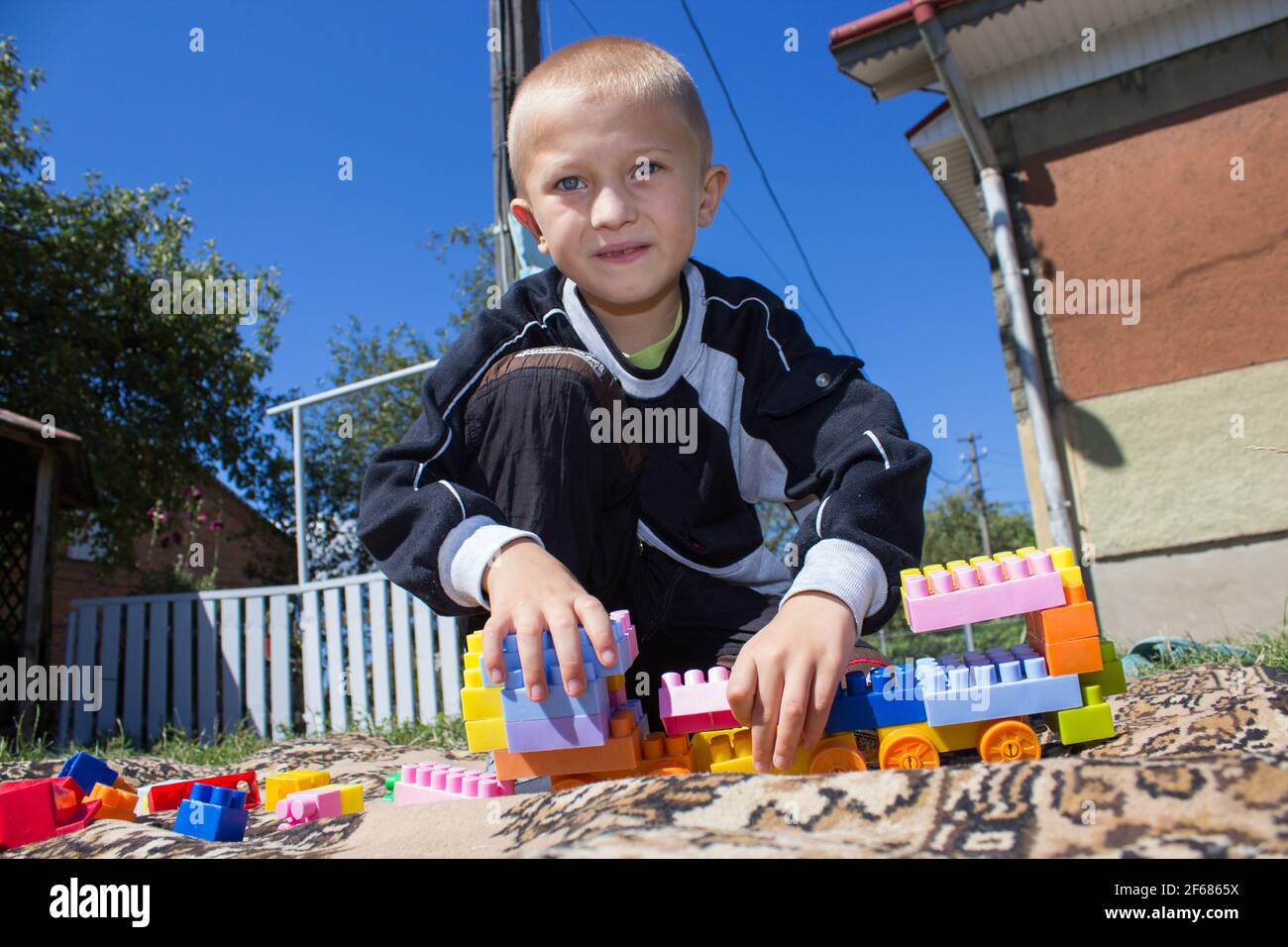 Junge spielt im Innenhof des Designer-Spielzeugs Stockfoto