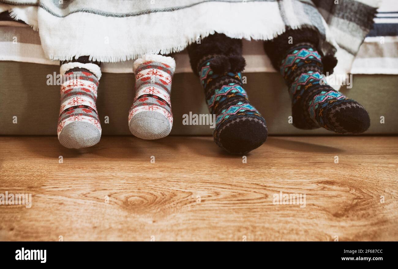 Zwei Kinder tragen Winterstrick Anti-Rutsch-Socken. Sie sind mit einer weißen Decke bedeckt Stockfoto