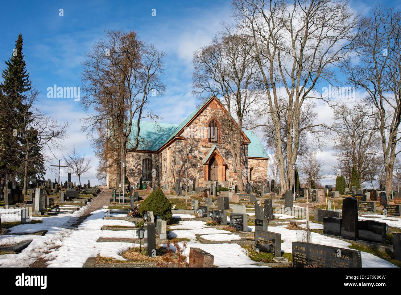 Mittelalterliche St. Michaels graue Steinkirche und Kirchhof mit Grabsteinen in Kirkkonummi, Finnland Stockfoto
