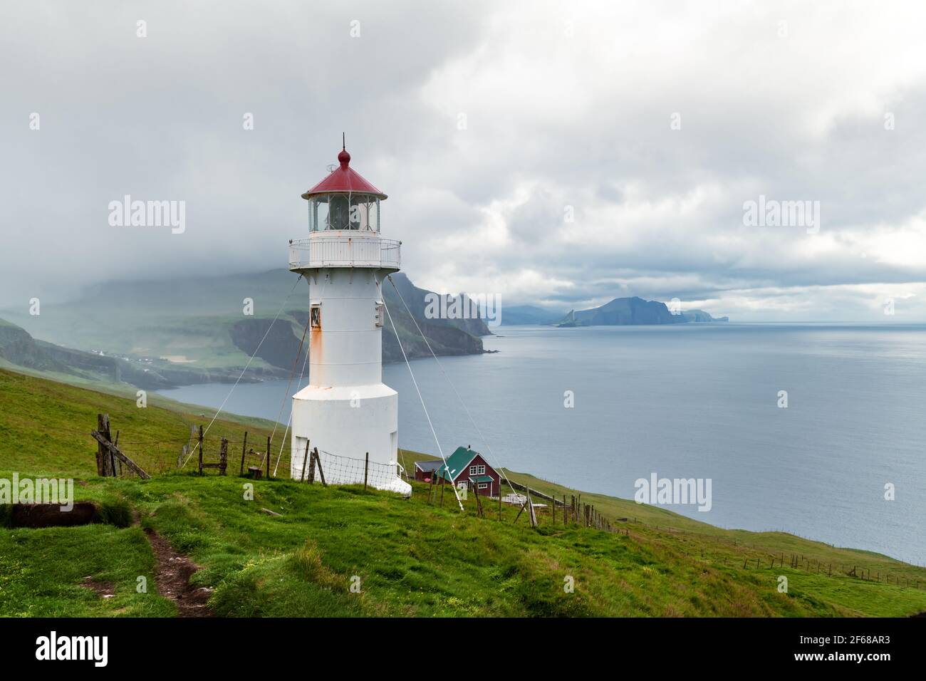 Nebliger Blick auf den alten Leuchtturm auf der Insel Mykines Stockfoto