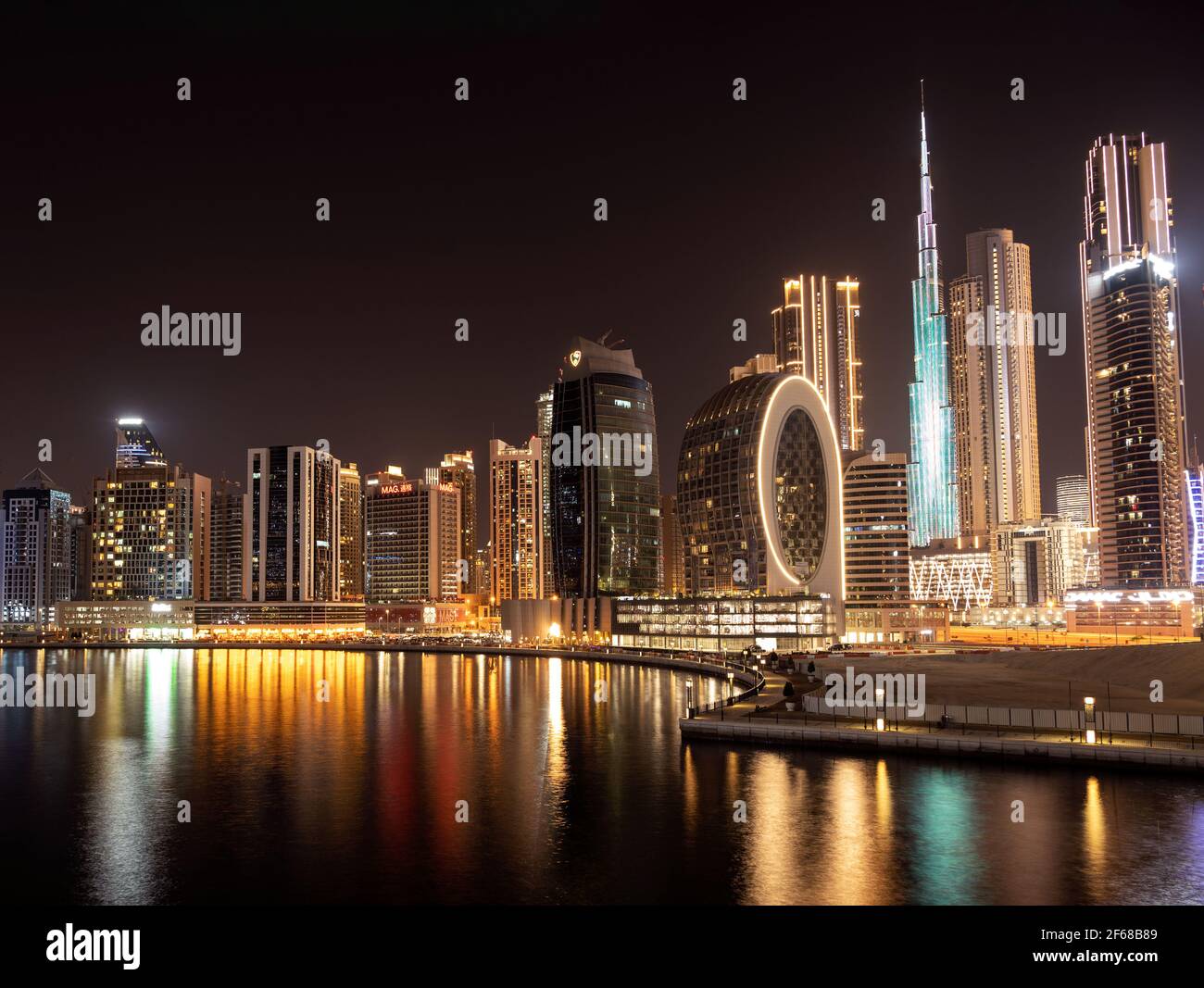 Wunderschöne Aussicht auf die beleuchteten Himmelsschrapper und den Burj khalifa, aufgenommen von der Marasi Drive im Business Bay District, Dubai, VAE. Stockfoto Wunderschöne Aussicht auf die beleuchteten Himmelsschrapper und den Burj khalifa, aufgenommen von der Marasi Drive im Business Bay District, Dubai, VAE. Stockfoto