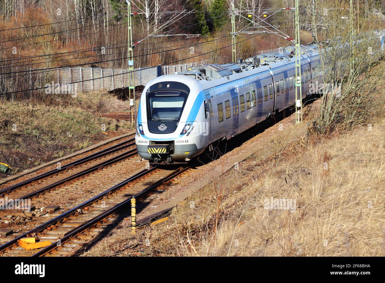 Sodertalje, Schweden - 30. März 2021: Blick auf einen Stockholmer Nahverkehrszug der Baureihe X60, der zum Bahnhof Ostertalje einfährt. Stockfoto
