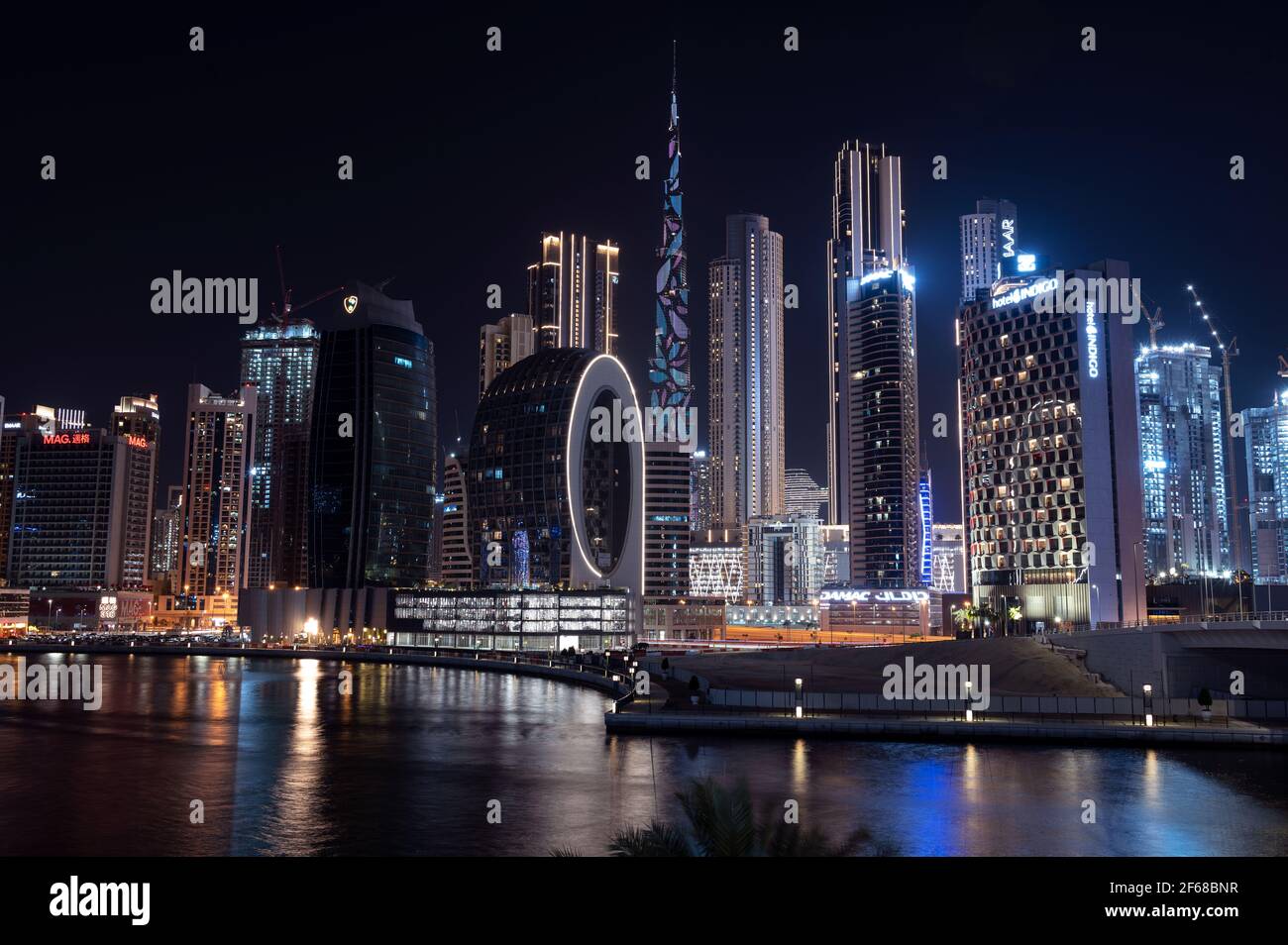 Wunderschöne Aussicht auf die beleuchteten Himmelsschrapper und den Burj khalifa, aufgenommen von der Marasi Drive im Business Bay District, Dubai, VAE. Stockfoto Wunderschöne Aussicht auf die beleuchteten Himmelsschrapper und den Burj khalifa, aufgenommen von der Marasi Drive im Business Bay District, Dubai, VAE. Stockfoto