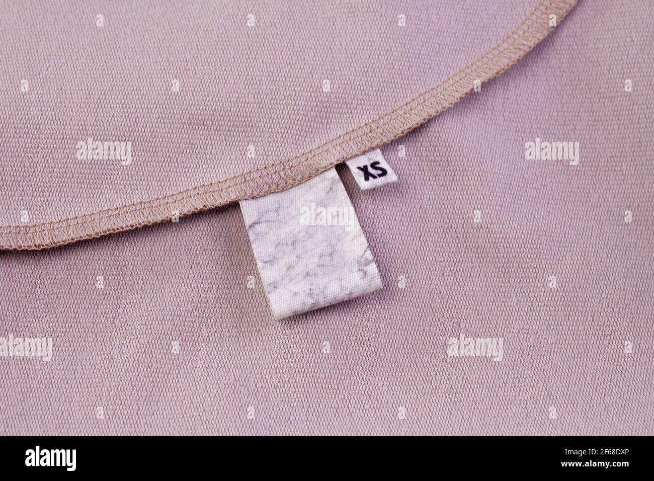 Makro-Mock Stoff blank weißen Tag für Kleidung Pflegehinweise Und Tag mit Größe XS in die Kleidernaht eingenäht Stockfoto