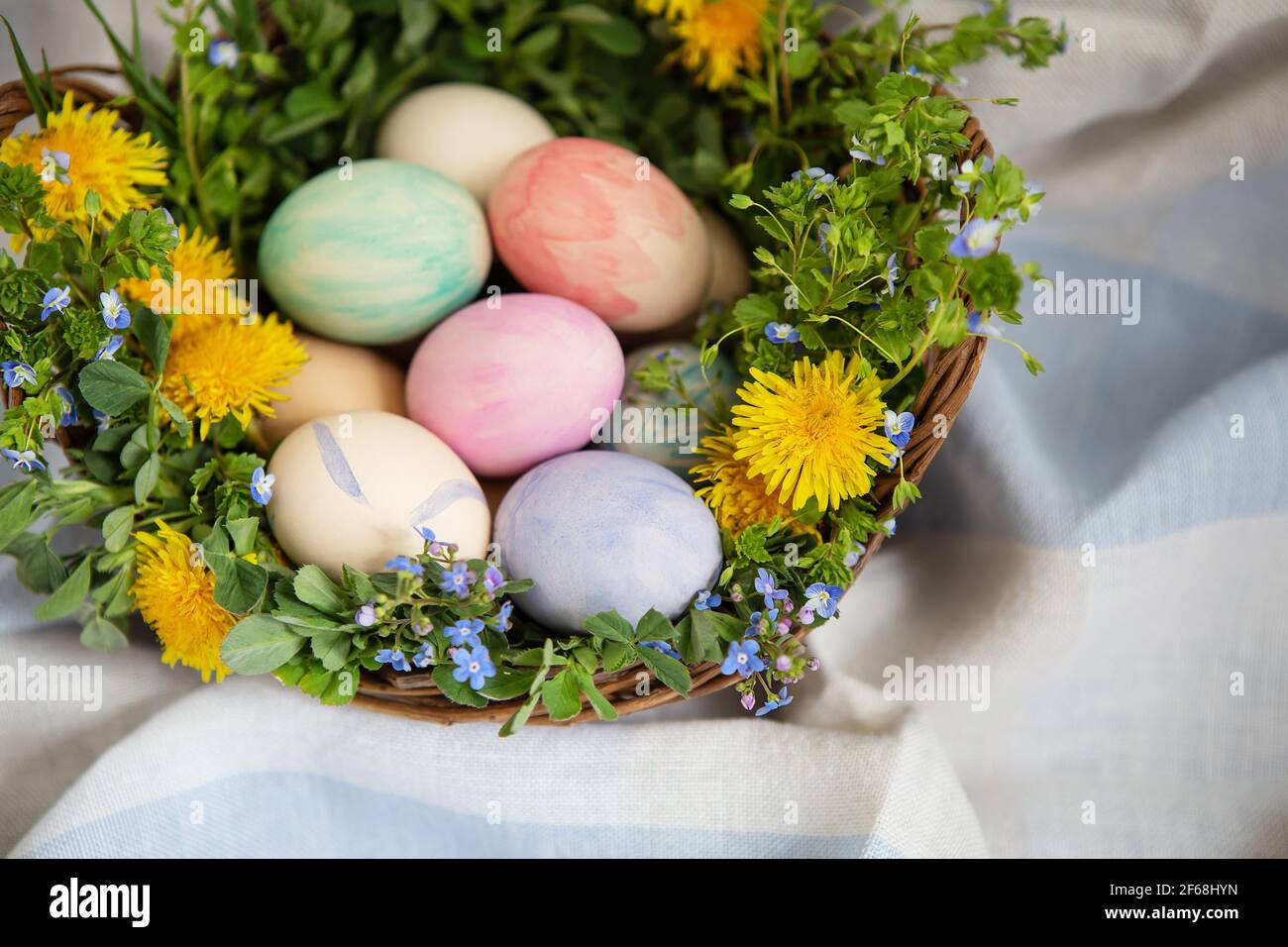 Ein schöner Frühlingsstrauß in einem Holzkorb mit Ostern Eier mit Aquarellen bemalt Stockfoto