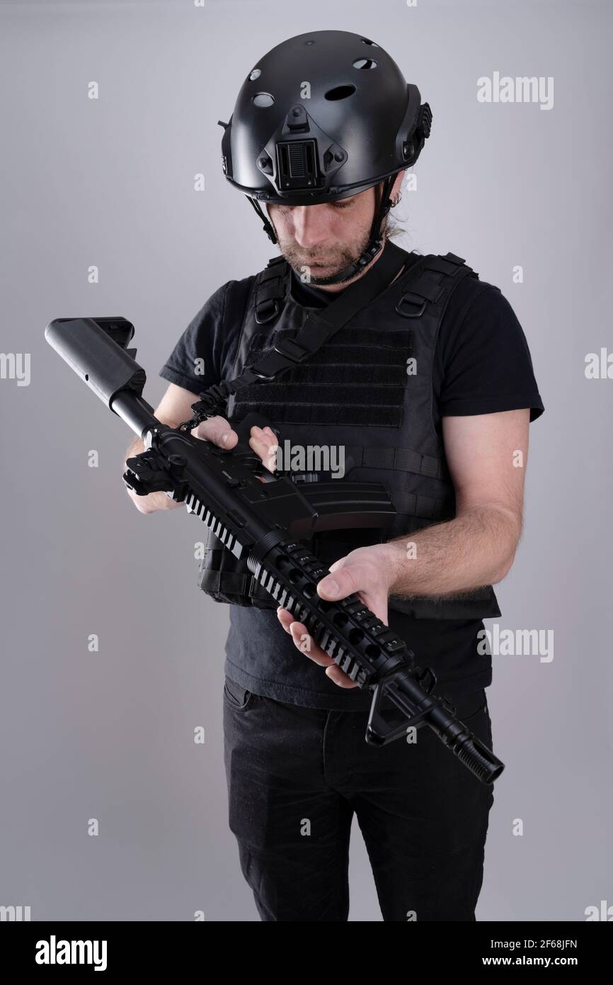 Ein einziger männlicher Schütze inspiziert seine Waffe. Stockfoto