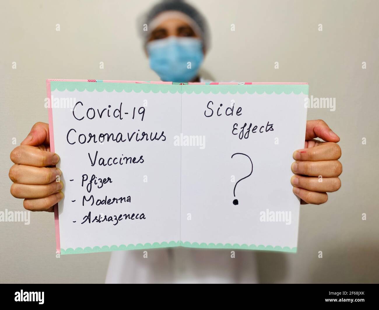 Eine Ärztin hält ein Schild, das die Nebenwirkungen verschiedener Covid-19-Coronavirus-Impfstoffe (pfizer, moderna, astrazeneca) in Frage stellt. Medizin vs. Ethik. Stockfoto