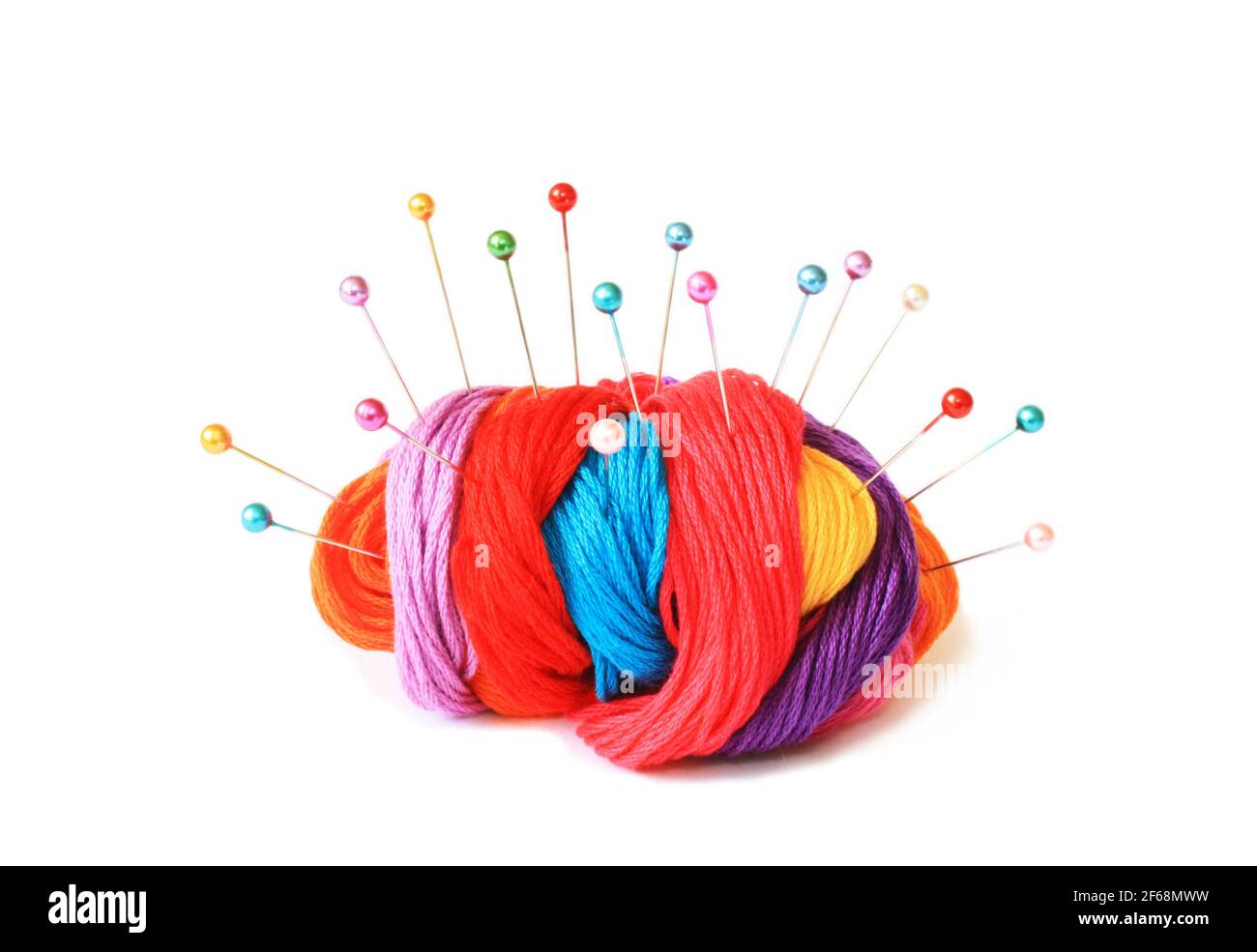 Mehrfarbige Stickfäden mit Perlstiften, angeordnet in Form eines Igels Stockfoto