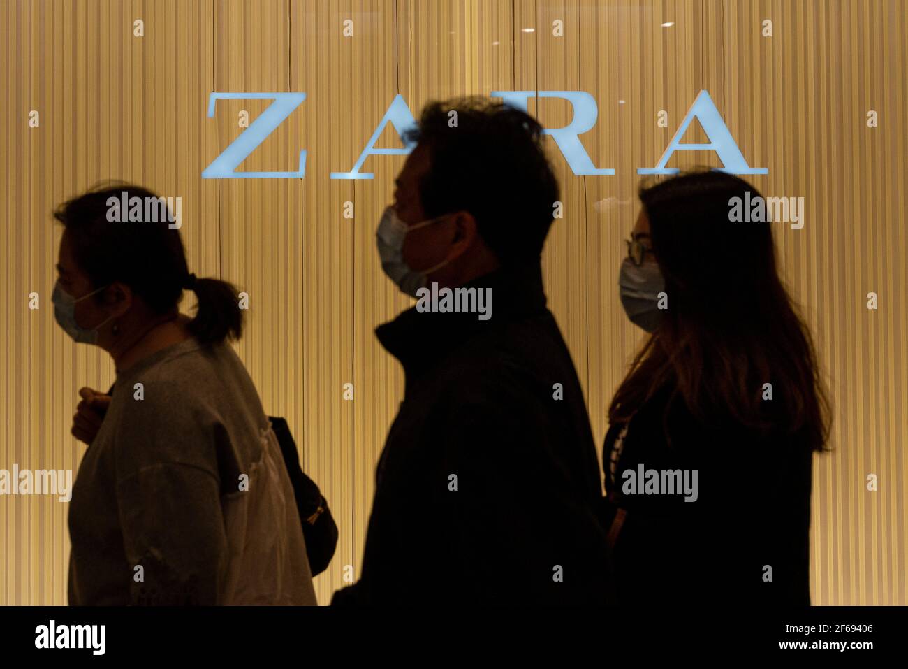 Die Käufer kommen an dem spanischen multinationalen Bekleidungsdesign-Einzelhandelsunternehmen by Inditex, dem Zara-Laden und -Logo in Hongkong vorbei. Stockfoto