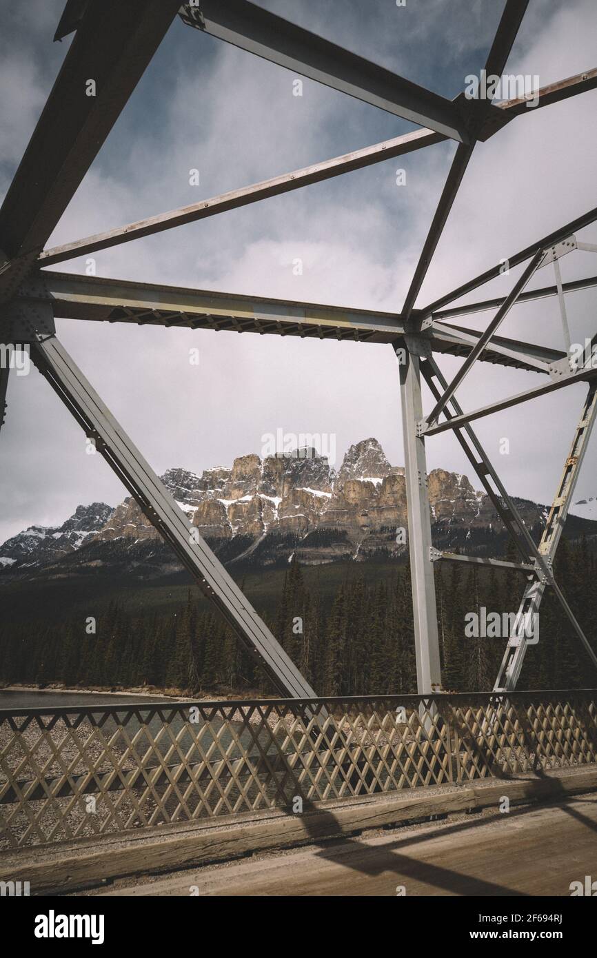 Stahlbrücke Schnee staubtes Schloss Mountian von der anderen Seite des Bow River. Stockfoto