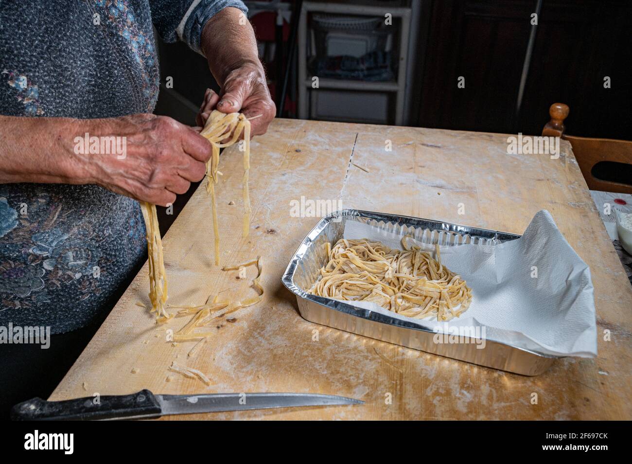 Oma arrangiert Nudeln auf der Aluminiumsohle Stockfoto
