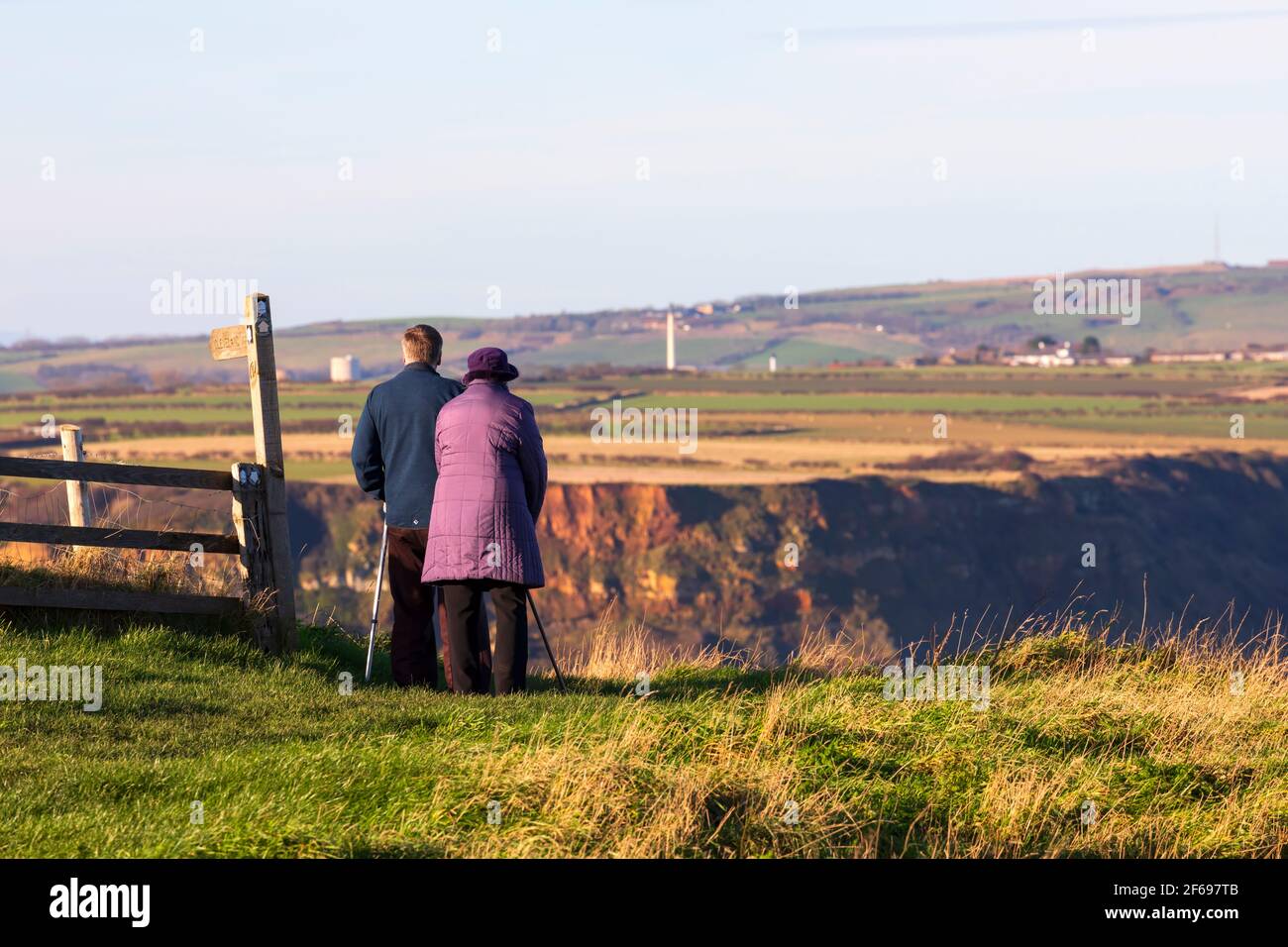 Ein älteres Paar blickt über Runswick Bay von Kettleness, Yorkshire Stockfoto
