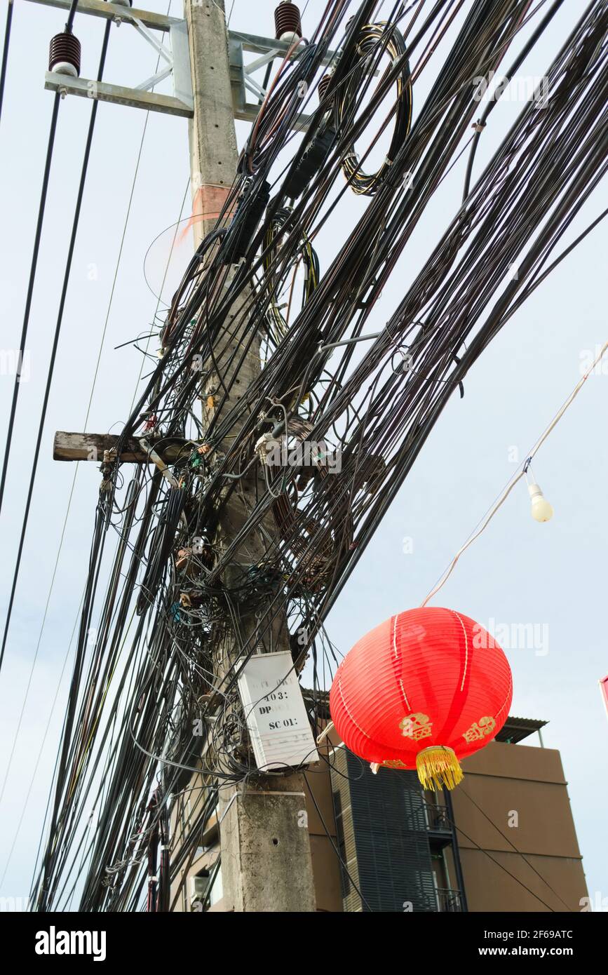 Chaotische, unordentliche Kabel an einem Mast in Phuket, Thailand. Stockfoto