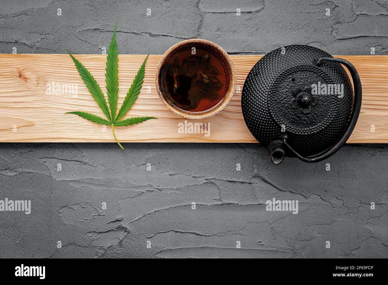 Vintage Teekanne mit Cannabis Kräutertee und frische Marihuana Blätter auf Beton Hintergrund gesetzt. Stockfoto