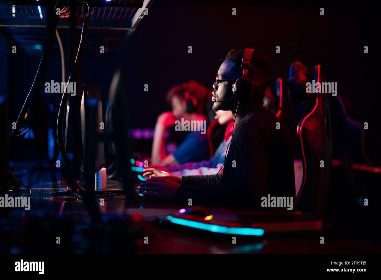 Porträt eines schwarzen Gamer mit Brille sitzt in einem Computer-Gaming-Stuhl. Training in eSports Spiele. Ein Team von Cyber-Athleten Stockfoto