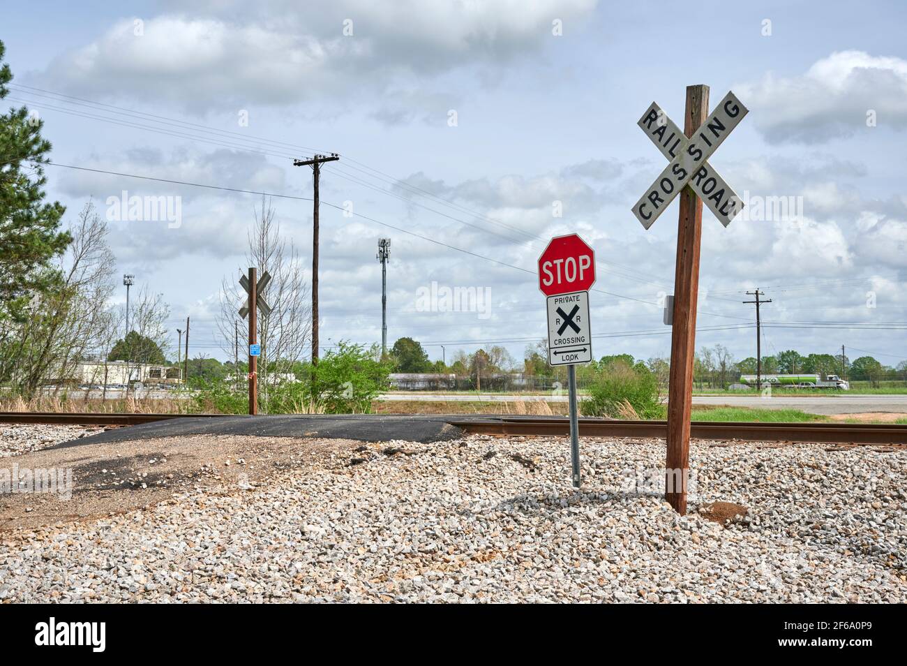 Unbewachte Bahngleise oder Bahnübergang mit Kreuzungsschildern und Stoppschild nur im ländlichen Alabama, USA. Stockfoto