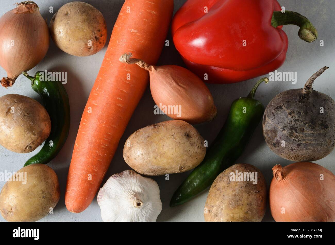 Set von Gemüse, Kartoffeln, Karotten, Zwiebeln, Knoblauch, Pfeffer, Rüben zum Kochen Borscht auf einem strukturierten gelb-grauen Hintergrund. Selektiver Fokus. Stockfoto