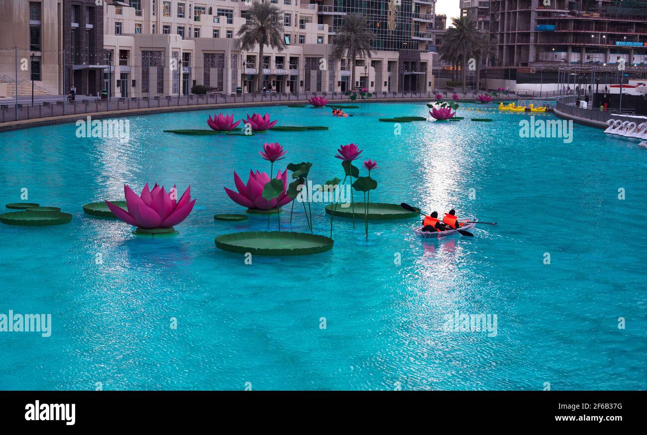 JANUAR 2021, DUBAI, VAE. TOURISTEN, DIE IM WUNDERSCHÖNEN LOTUS-POOL AUF DEM ERHOLUNGSBOULEVARD DES BURJ PARK, DUBAI, VAE, MIT BOOTEN FAHREN Stockfoto