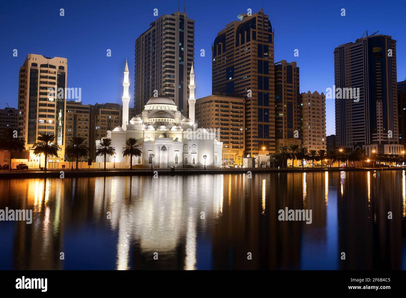 Blick auf die wunderschön beleuchtete Al Noor Moschee während der Frühe Sonnenaufgangsstunden, die Reflexionen im Wasser zeigen, das von Al aufgenommen wurde Noor Island Sharjah Stockfoto