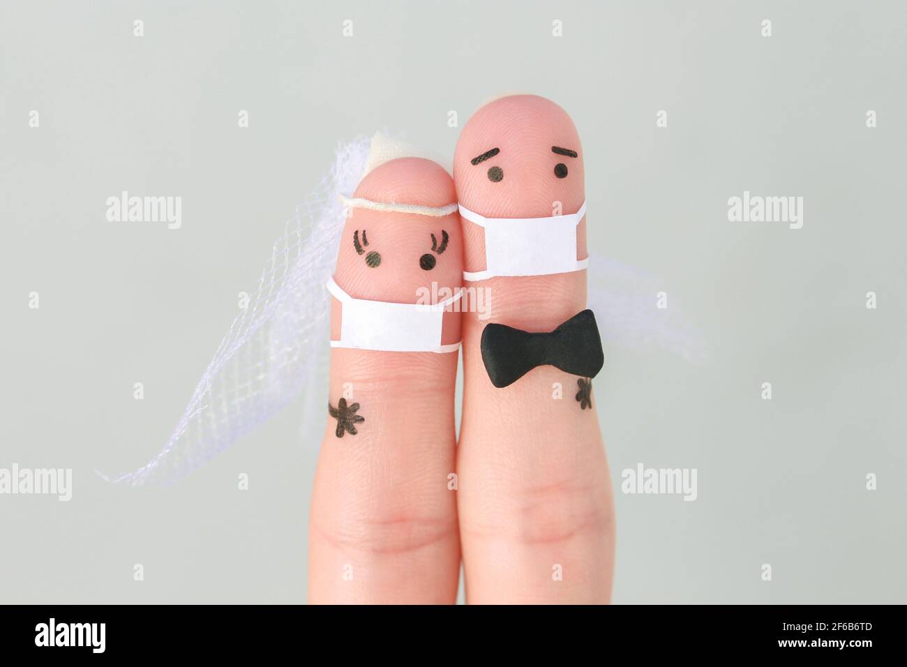 Finger Kunst des glücklichen Paares in medizinischer Maske von COVID-2019. Konzept der Hochzeitszeremonie. Stockfoto