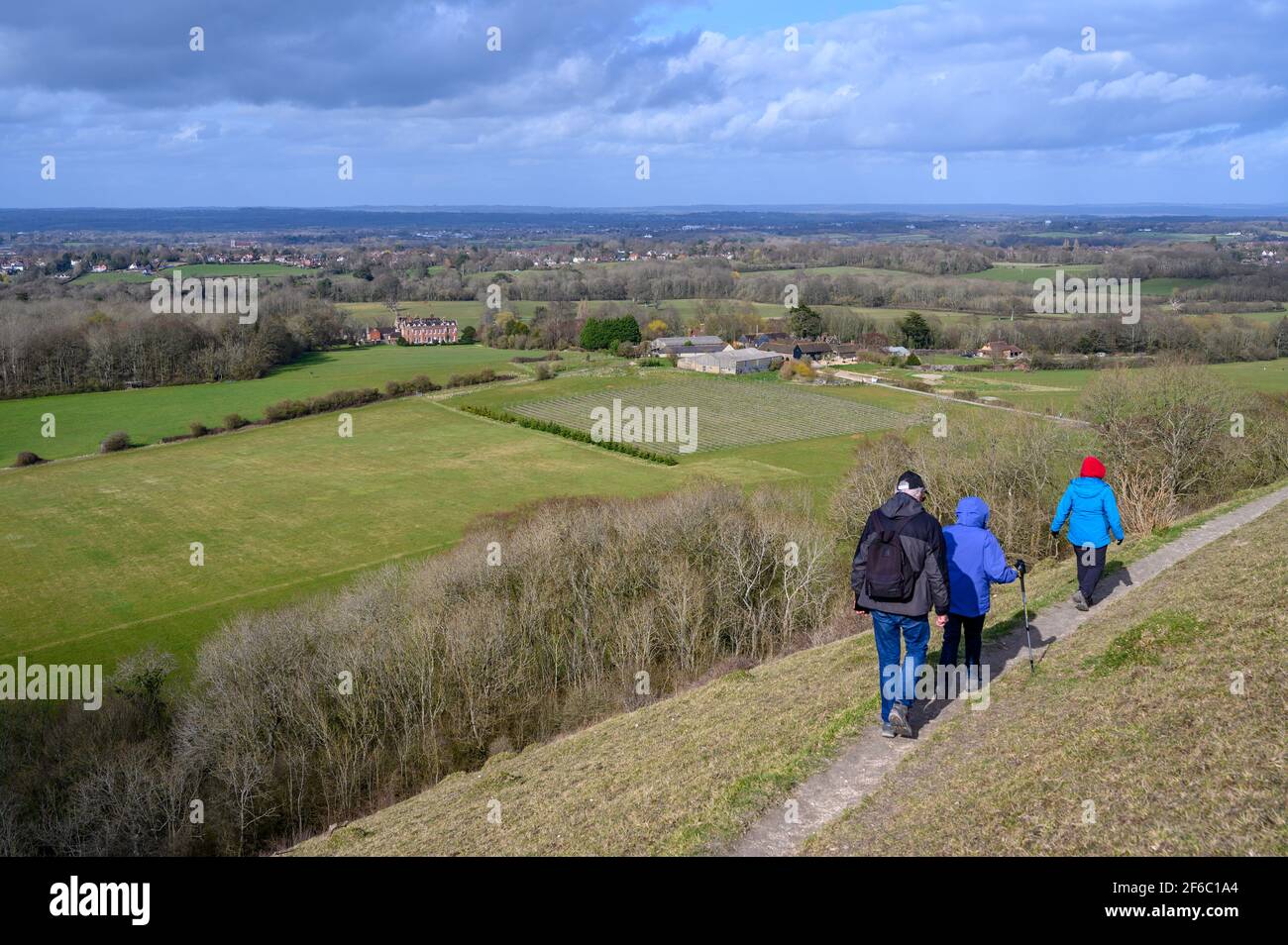 Spaziergänger auf dem Wolstonbury Hill im South Downs National Park in West Sussex, England, mit Blick auf Danny House und Woolstonbury Vineyard. Stockfoto