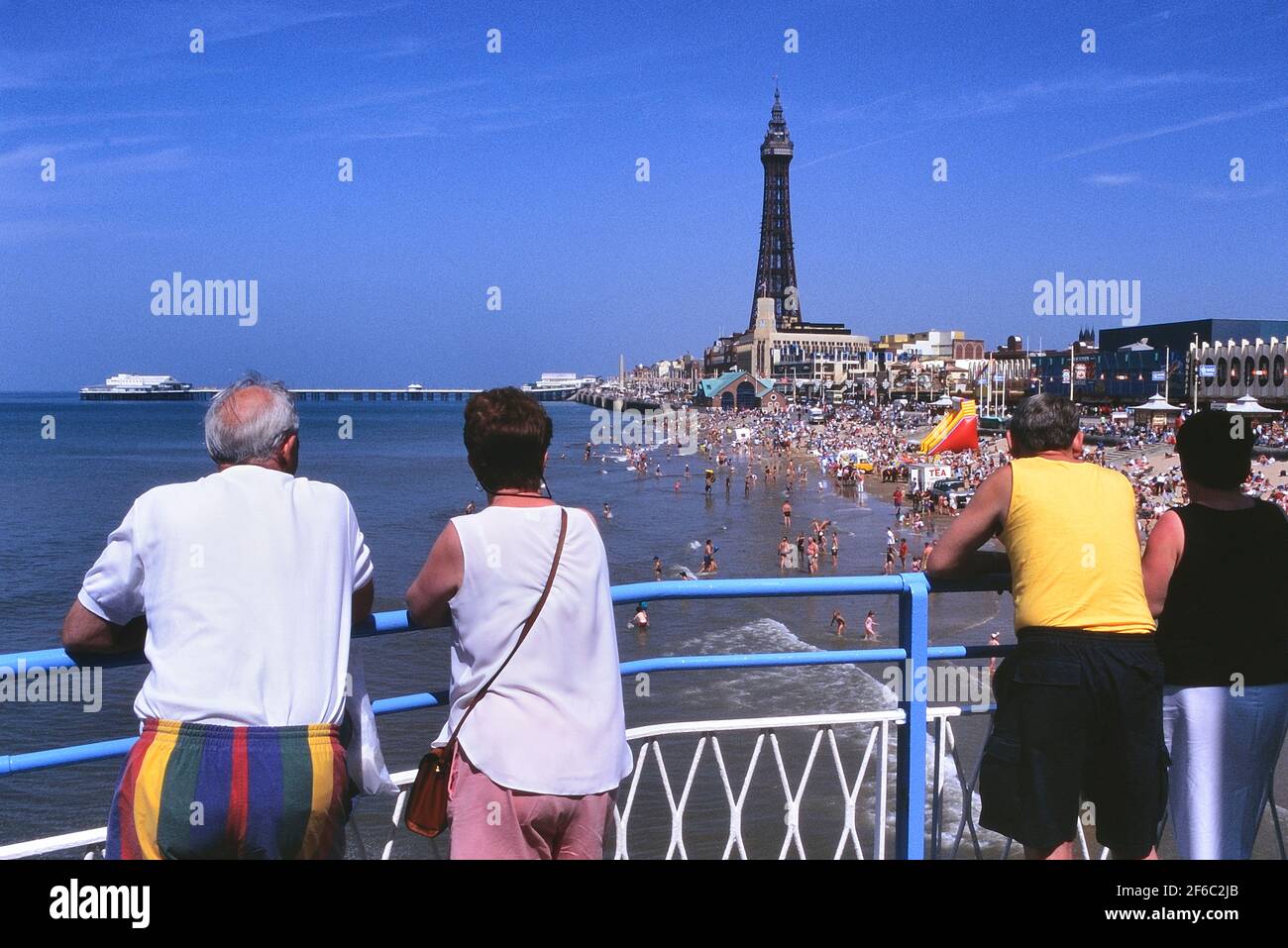 Urlauber am Central Pier mit Blick auf den Strand, North Pier & Tower, Blackpool, Lancashire, England, Großbritannien Stockfoto