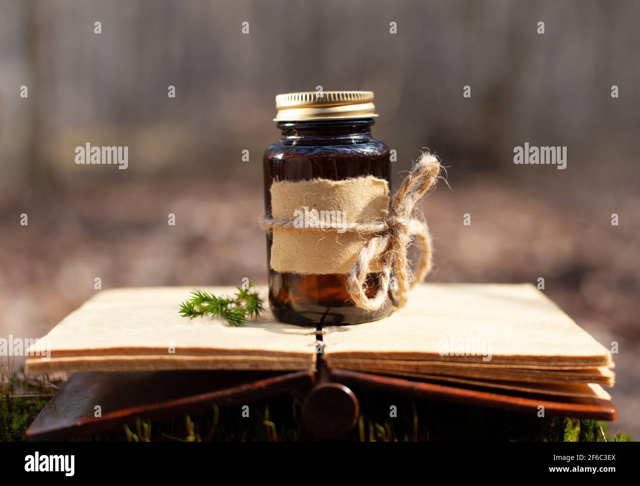 Selektive Aufnahme einer medizinischen Flasche über einem alten Buch im Vintage-Stil. Speicherplatz für tekst kopieren. Stockfoto