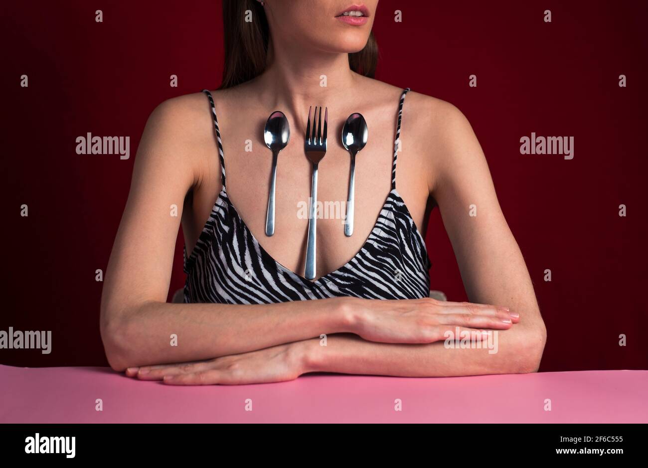 Magnetische Frau mit Löffeln auf seiner Haut. Stockfoto