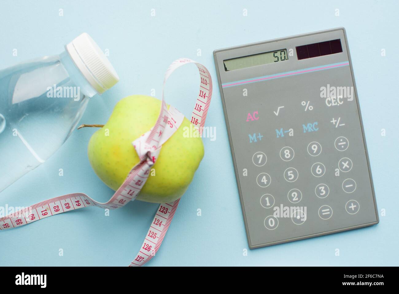 Taschenrechner, Flasche Wasser, Apfel mit Maßband auf blauem Hintergrund.  Weight Loss, Kalorienzählen und gesunde Ernährung Konzept - berechnen Sie  täglich Stockfotografie - Alamy