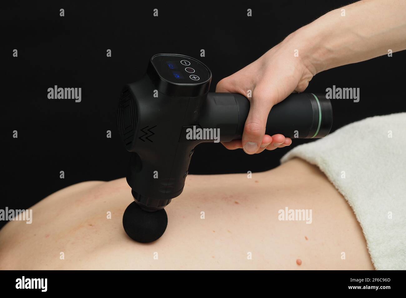 Hardware Rückenmassage. Der Percussion-Apparat. Der Patient liegt auf der Massageliege. Stockfoto