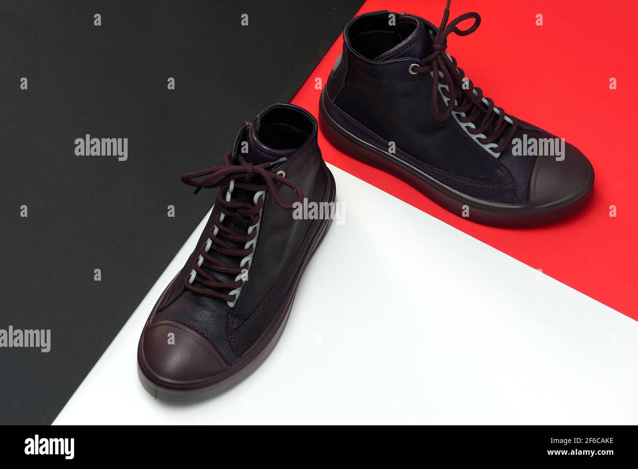 Ein Paar trendige stylische Schuhe oder Sneaker auf einem Farbiger Hintergrund mit Platz für Text Stockfoto