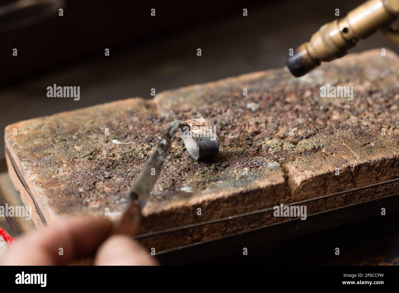 Goldschmied Juwelier Löten einen Silberring auf der Werkbank mit einem Löten. Stockfoto